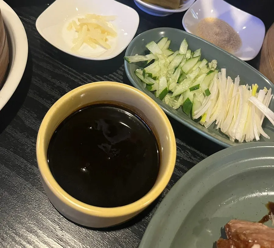 煎餅上放著北京烤鴨與蔬菜的一捲