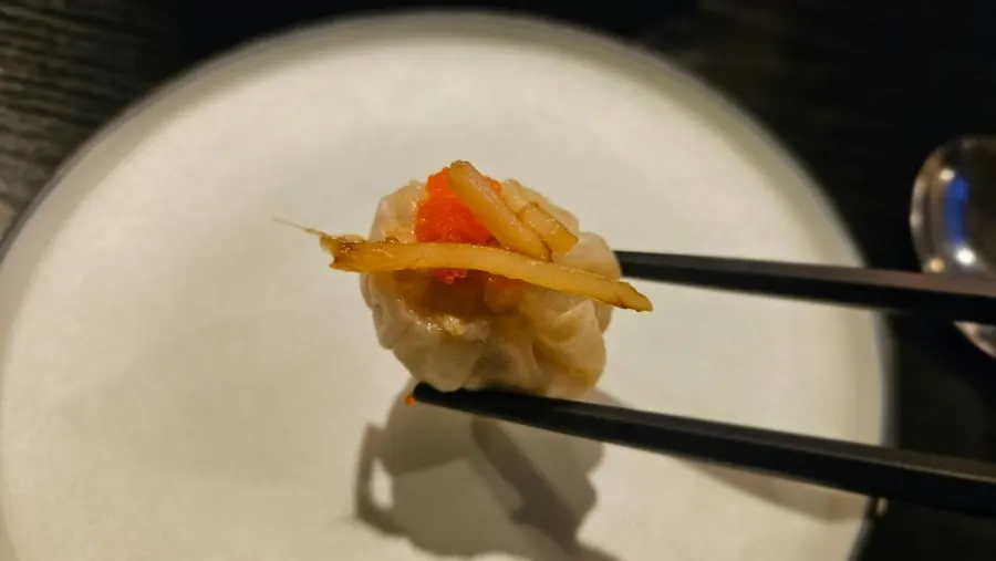Cross-section of flying fish roe shumai picked up with chopsticks