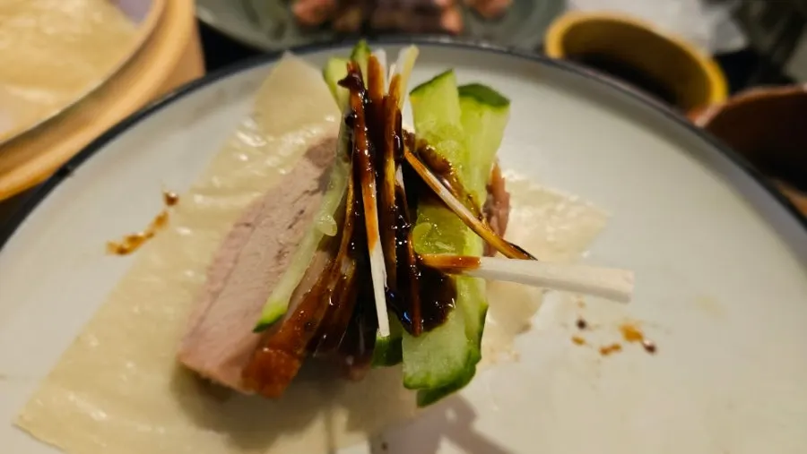 A finished bite of Peking duck with added sauce