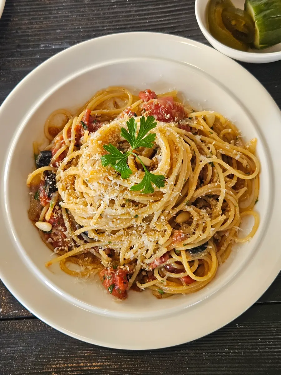 Close-up of anchovy pasta sprinkled with grated cheese