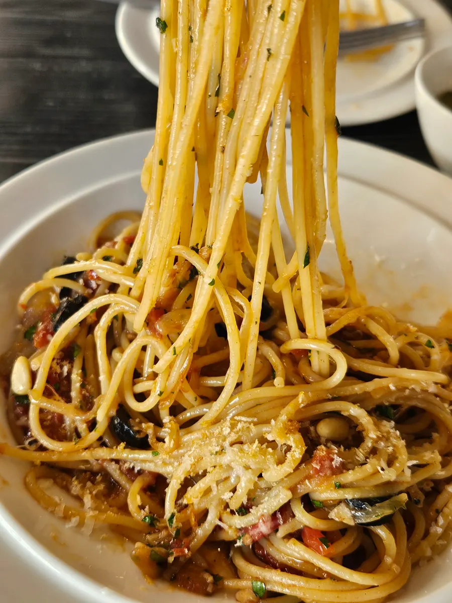 Anchovy pasta noodles twirled on a fork
