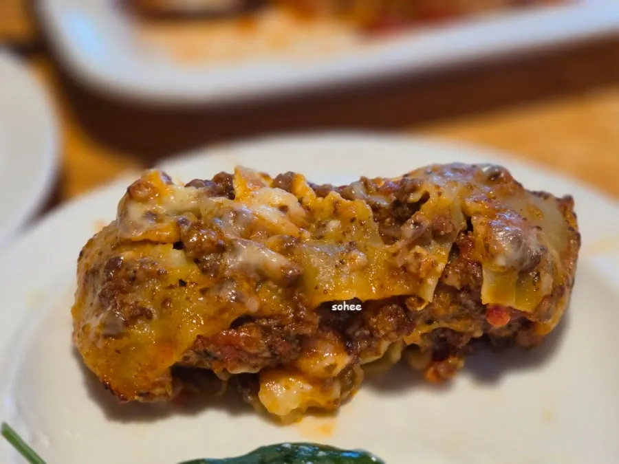 Andover lasagna cut in half with a knife, showing the cross-section