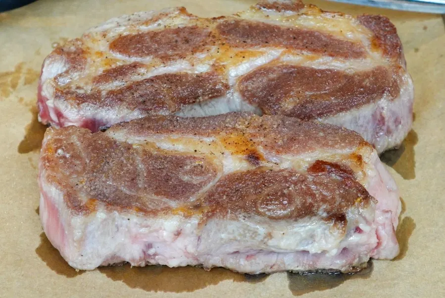 Iberico thick pork neck being grilled in two rounds