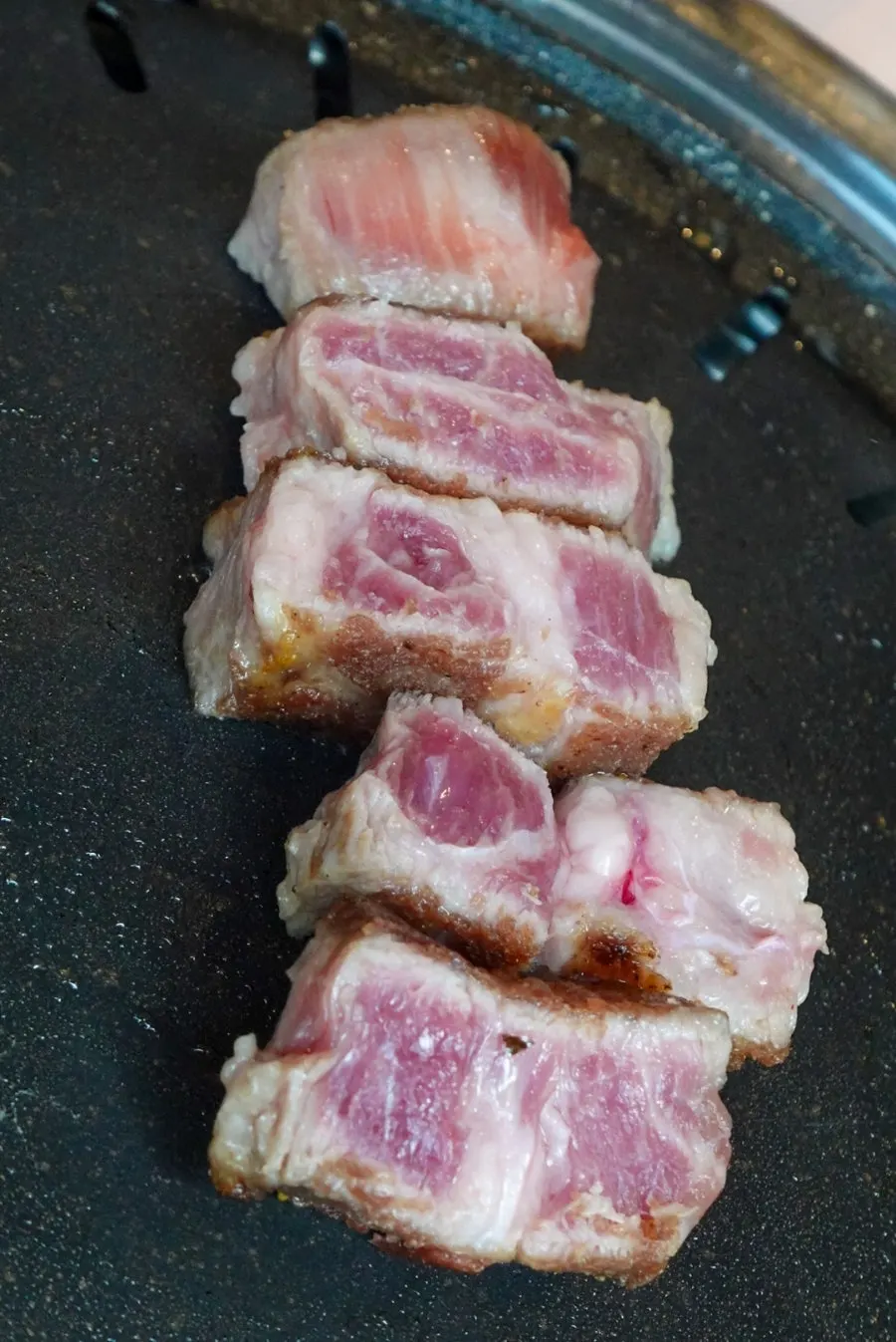 Staff member checking the meat as it grills