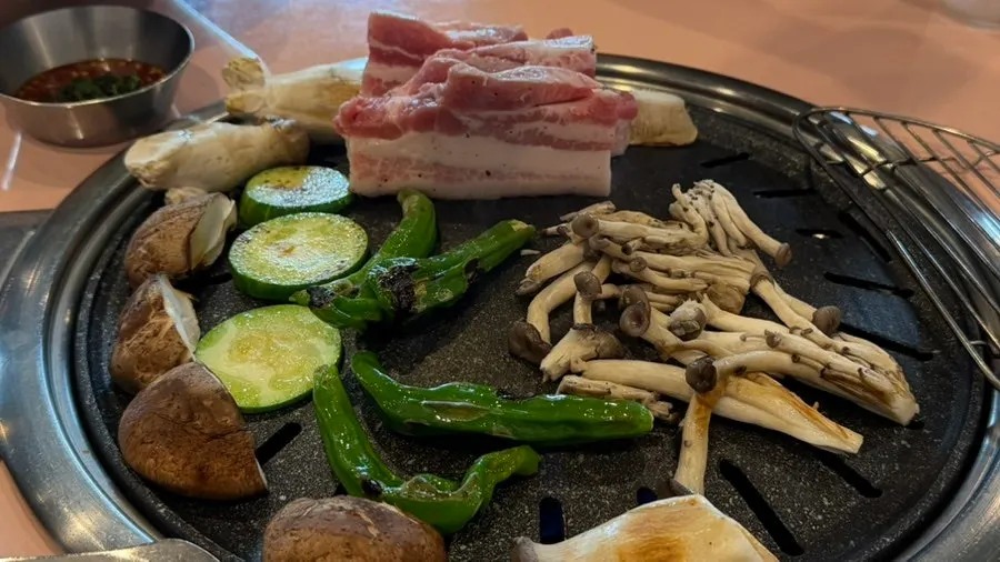 Staff grilling meat and vegetables on the plate