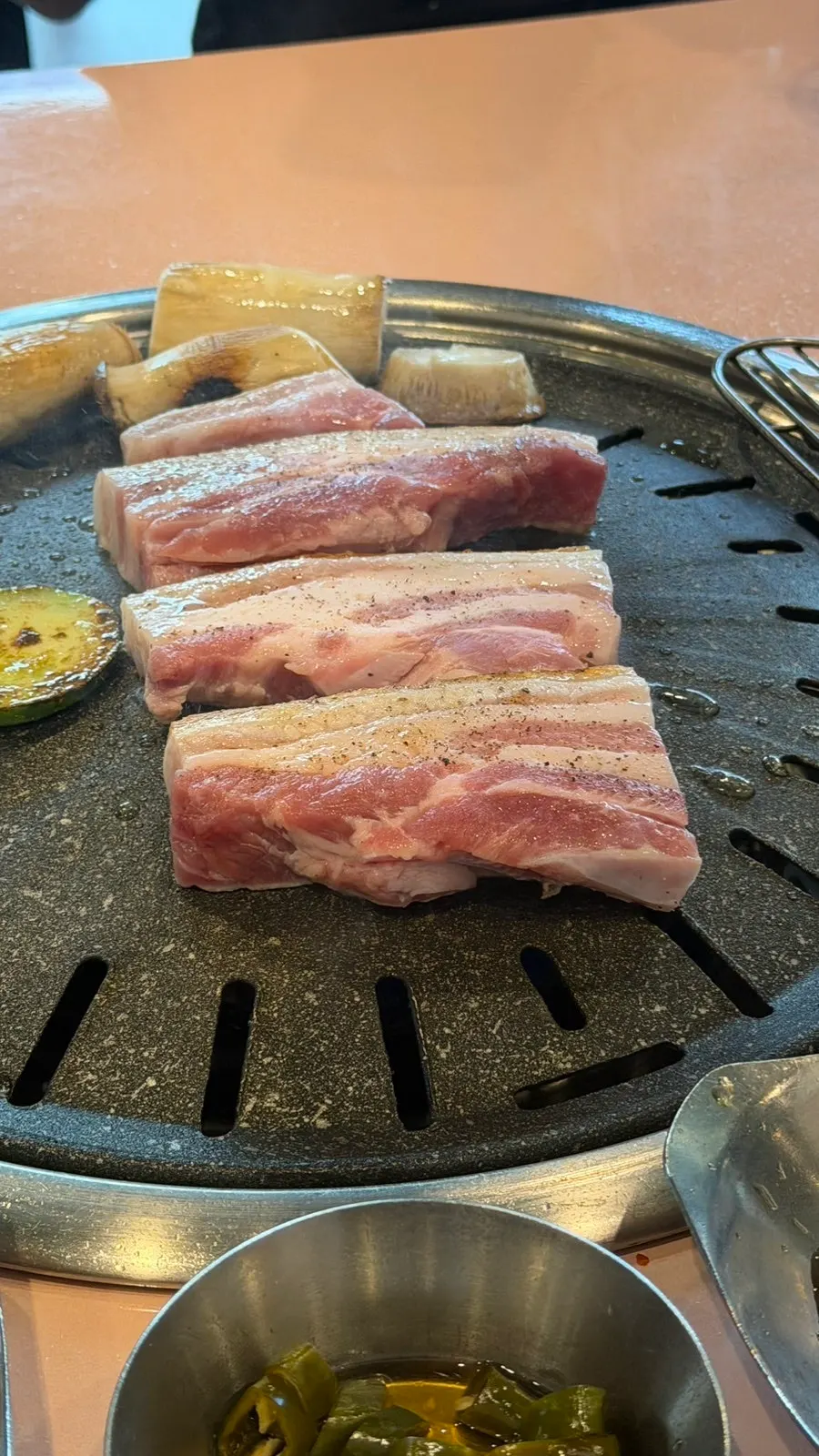 Pork belly and vegetables cooking quickly over the charcoal