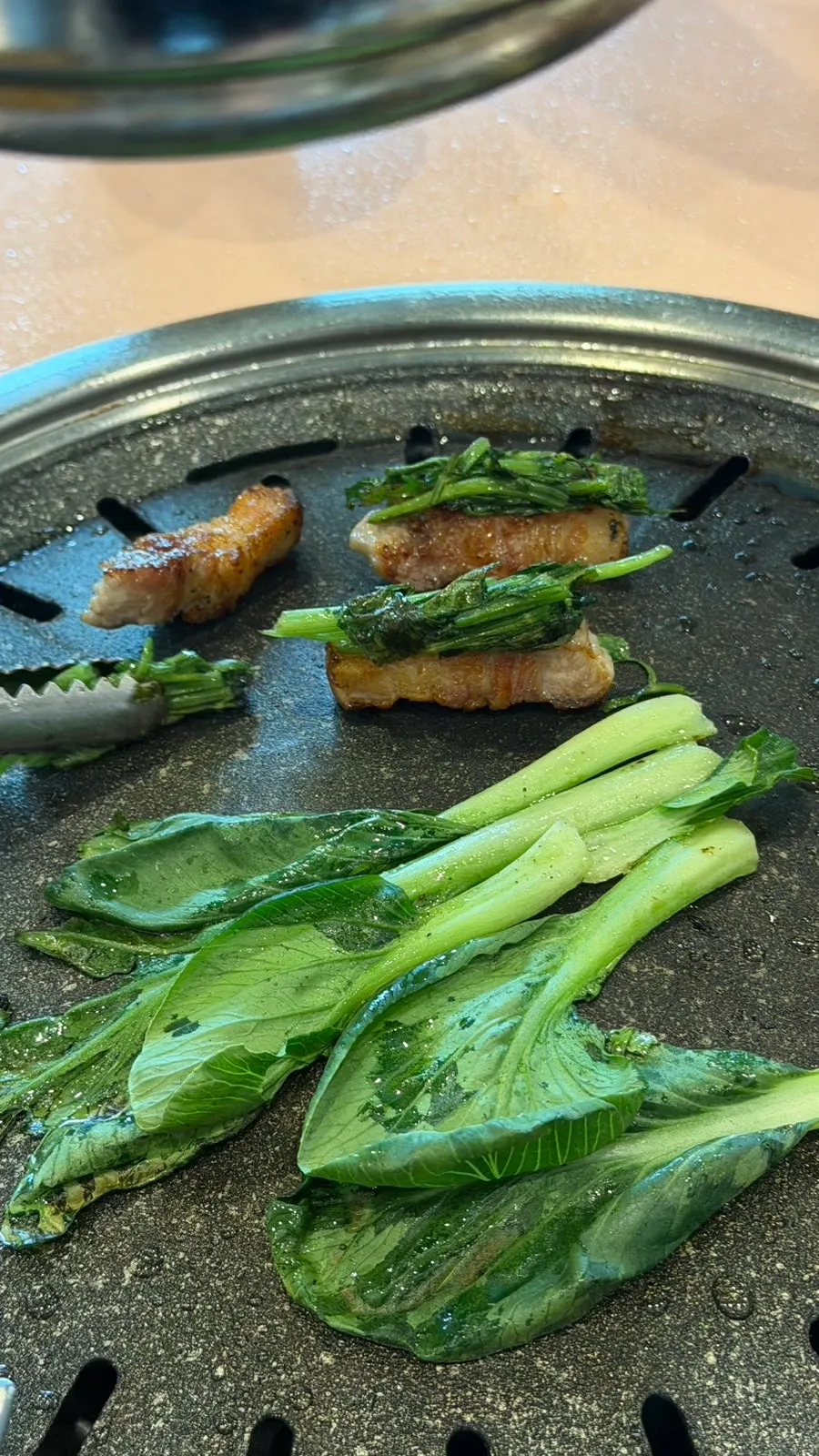 Golden pork belly and grilled minari placed on a stand