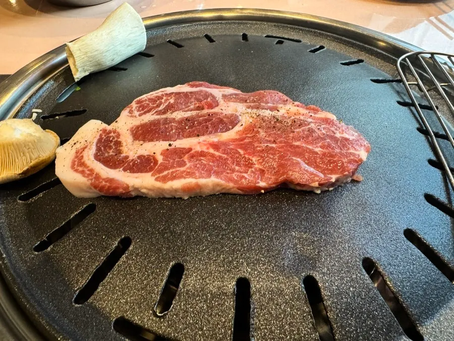 Staff grilling pork belly and pork neck on the grill