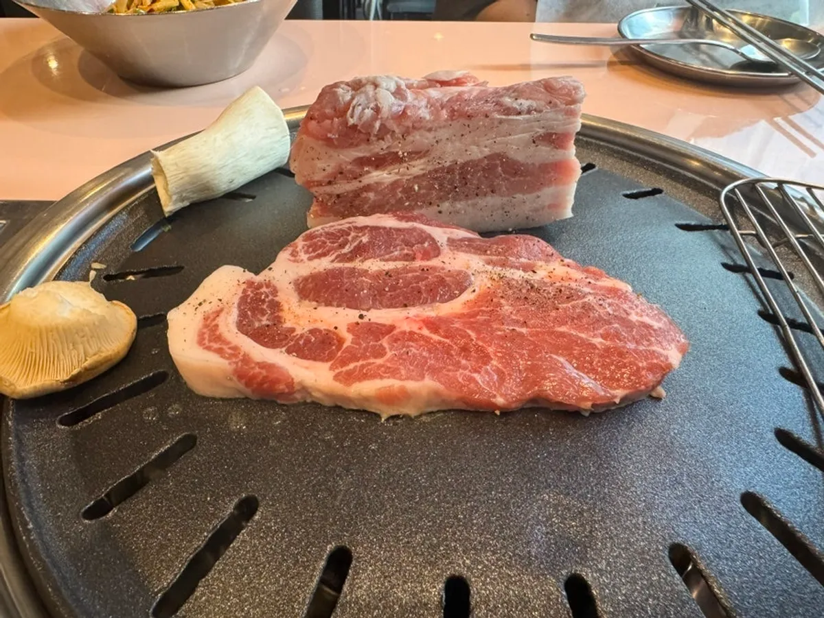 Thick pork belly cooking on the grill