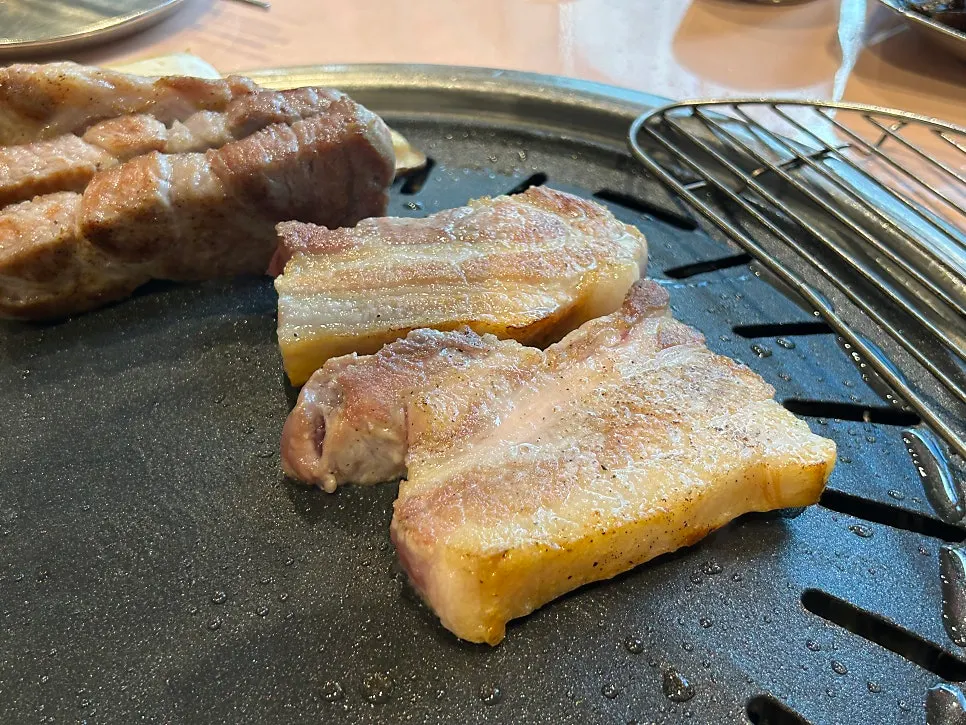 직원이 불판에서 삼겹살을 굽는 모습