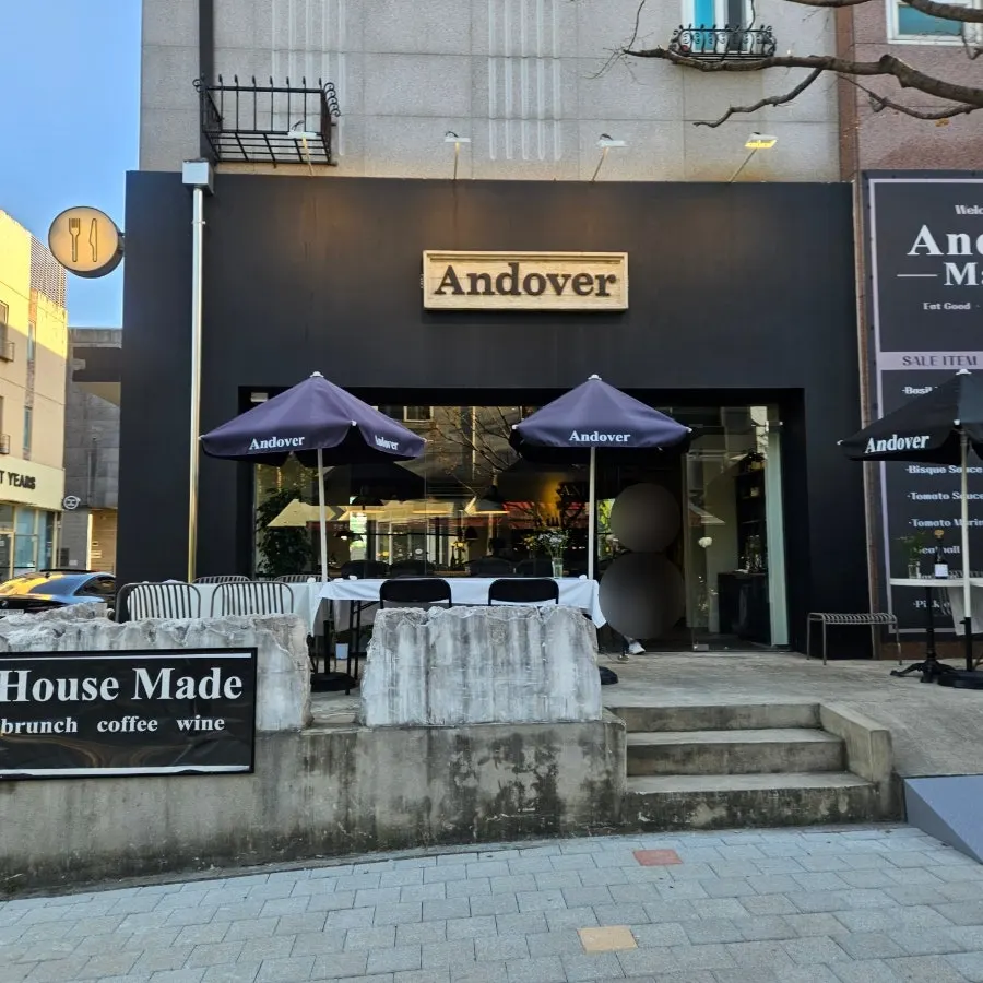 Entrance of Andover with black exterior and wood sign