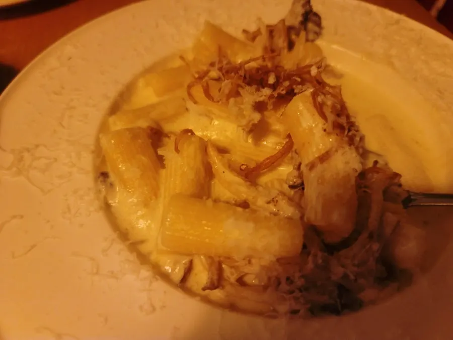 A forkful of truffle cream pasta lifted up