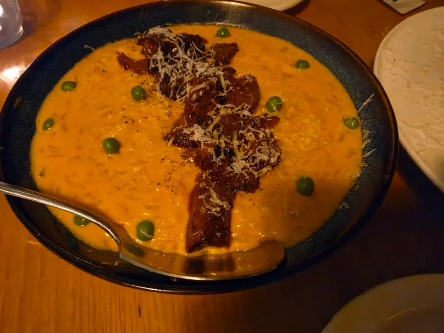 A spoonful of rosé risotto topped with spicy jokbal meat