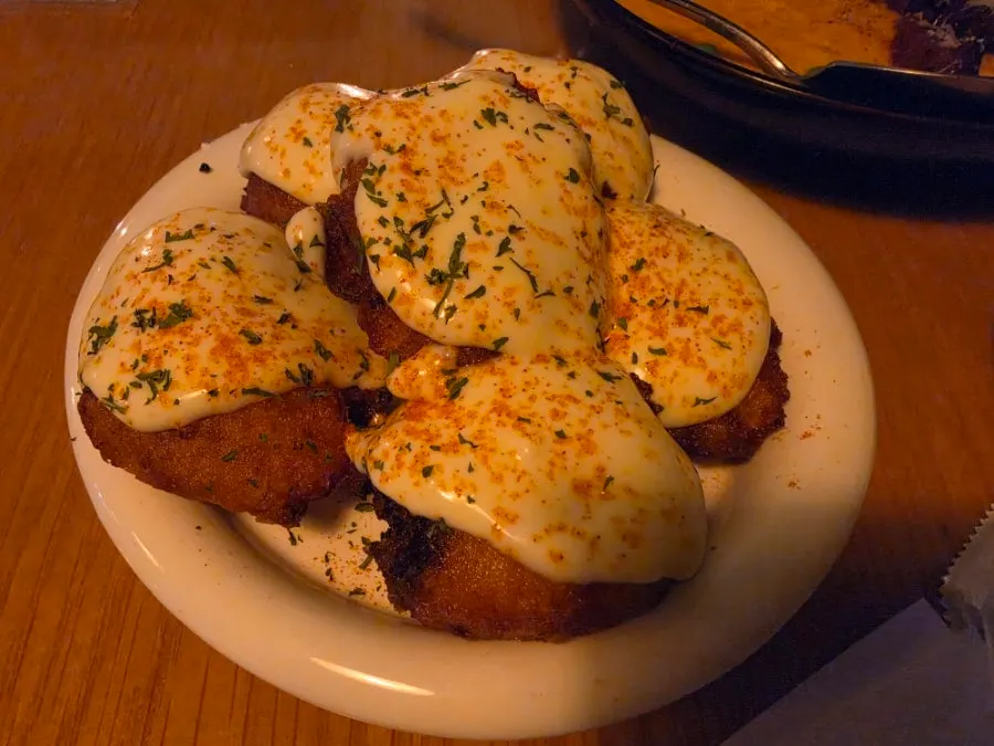 Close-up of baby potato fries topped with truffle cream sauce