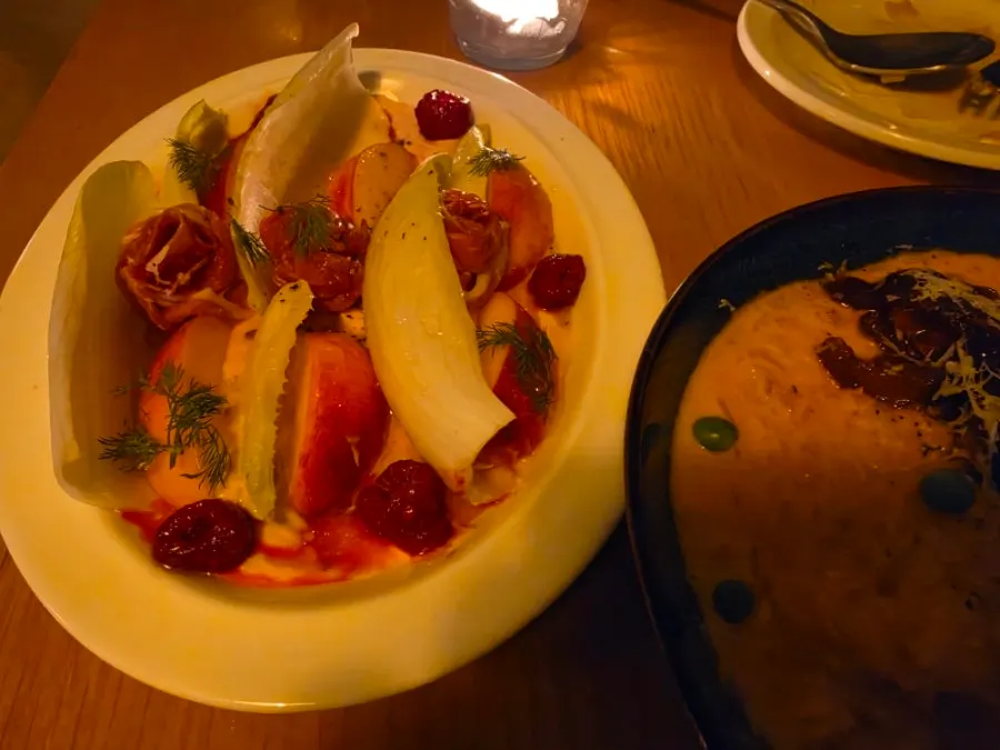A piece of endive topped with peach and jamón