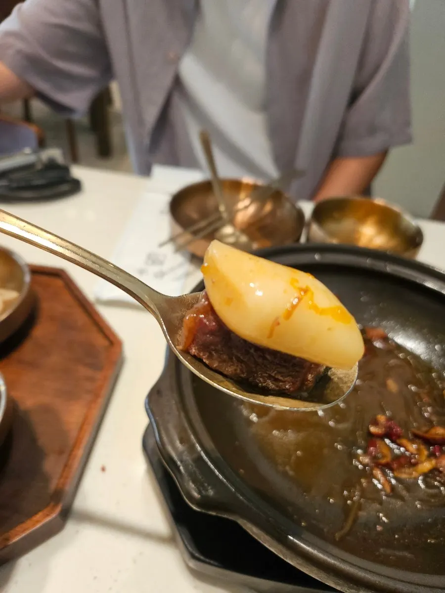따뜻한 밥 위에 올린 갈비찜 고기 한 조각