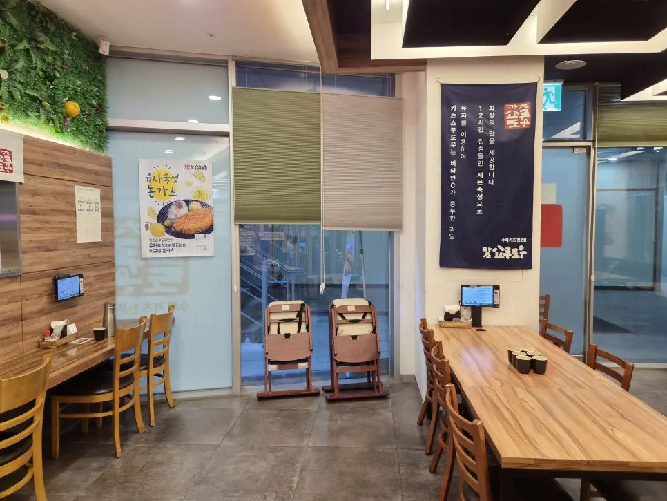 Dining hall with open kitchen and neon sign visible
