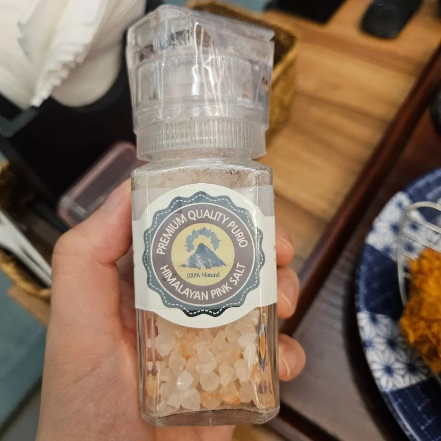 テーブルの隅にあるピンク塩のグラインダー