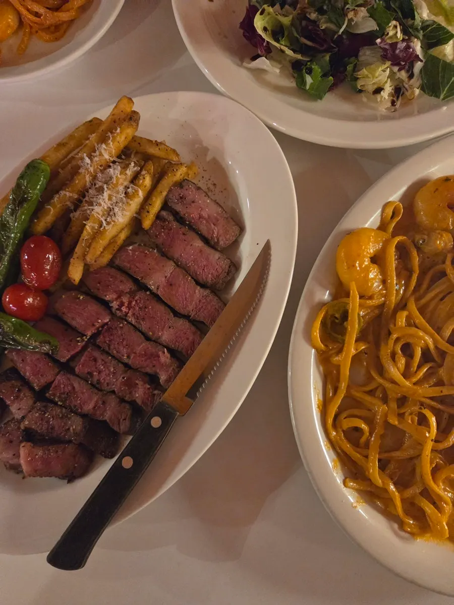Full table spread with steak and pasta together