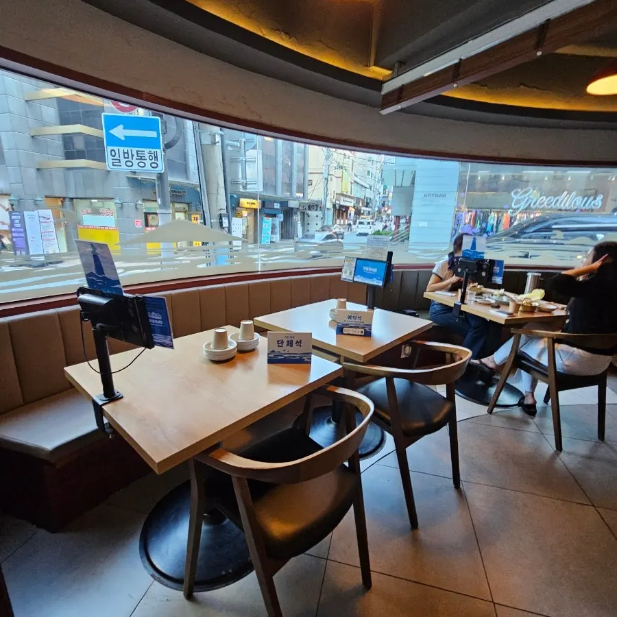 Window seating inside Parang Haenyeojip Sinsa with floor-to-ceiling glass