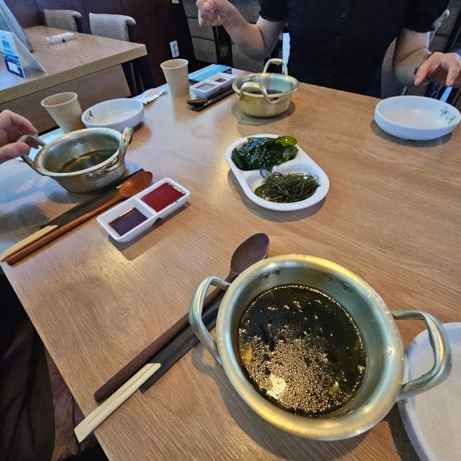Warm miyeok-guk seaweed soup served in a brass pot