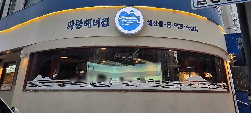 Parang Haenyeojip's white wall and blue sign