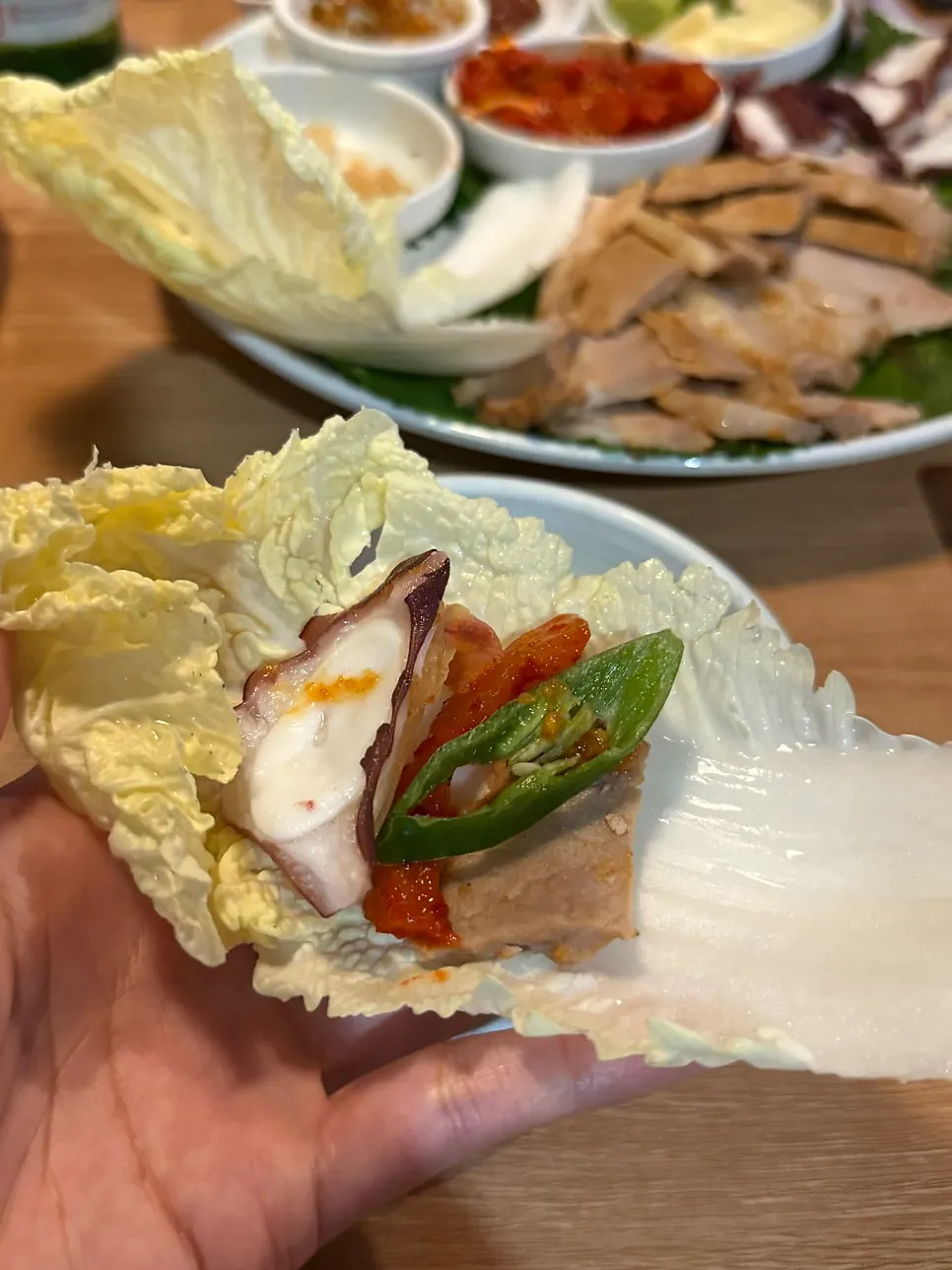 Bossam pork and octopus sashimi served with napa cabbage