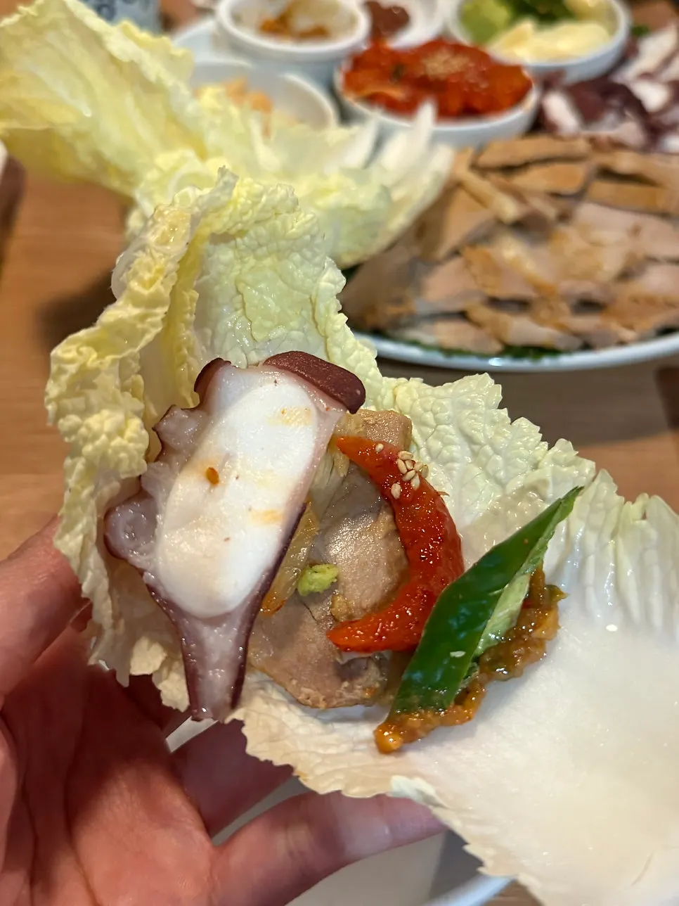 Side dishes of ssamjang, aged kimchi, and cheongyang peppers