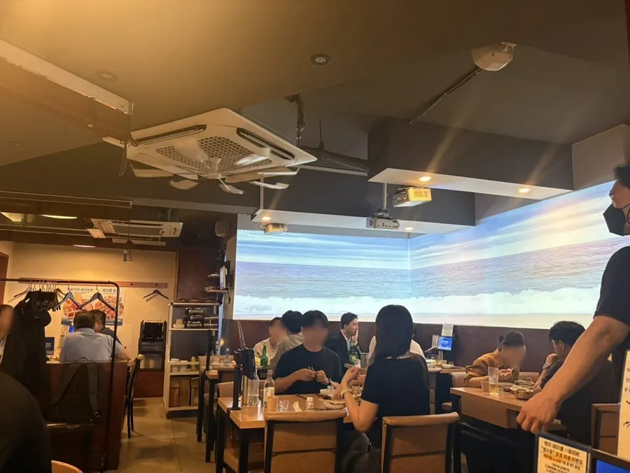 Seating area at Parang Haenyeojip with an ocean screen
