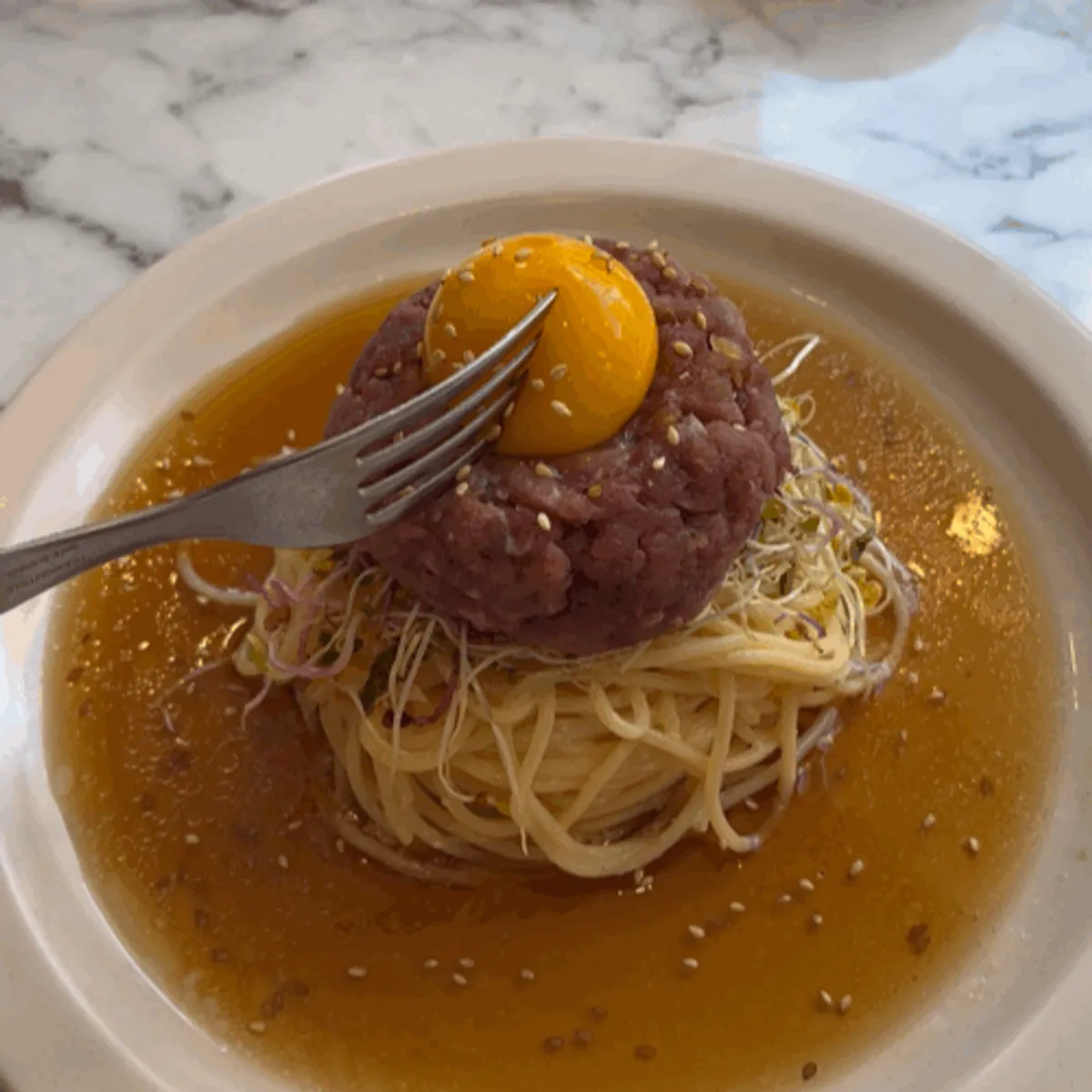 Close-up of the noodles and beef tartare in the perilla oil pasta