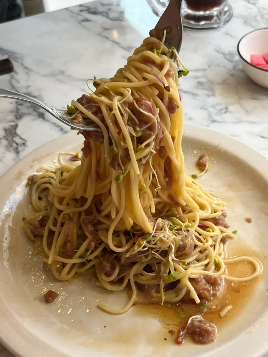 Glossy noodles of the perilla oil beef tartare pasta lifted up