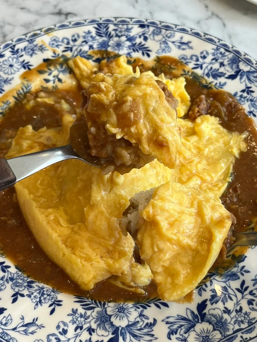 A spoonful of omurice lifted up