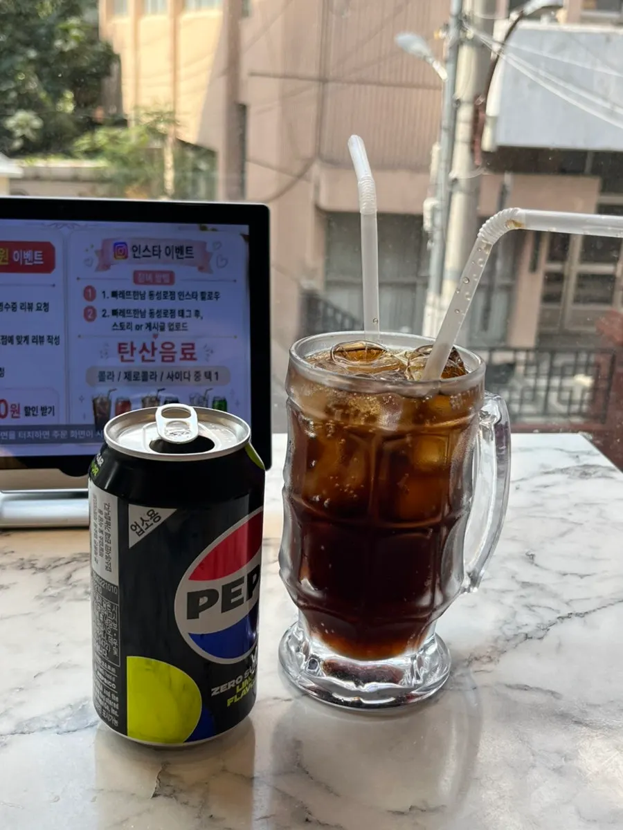 The pasta, omurice, and a Pepsi Zero on the table