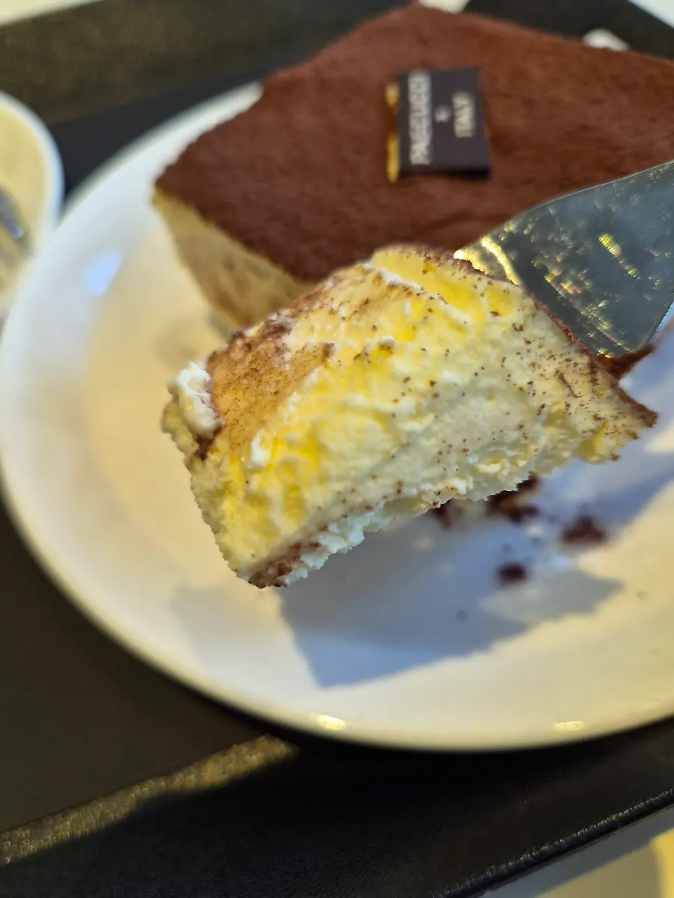 Cross-section of tiramisu dusted with cocoa powder