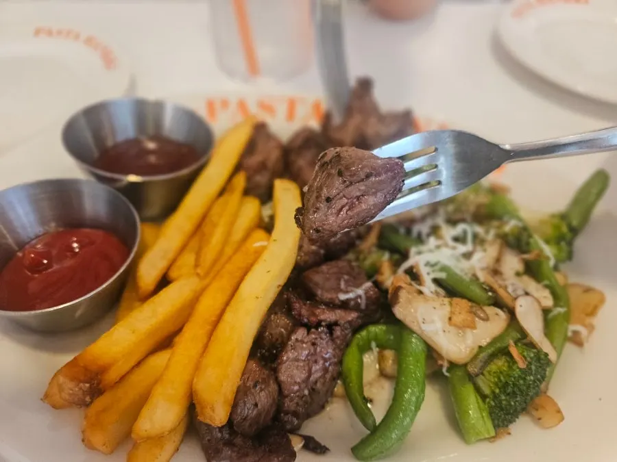 A plate of skirt steak with grilled vegetables and potatoes