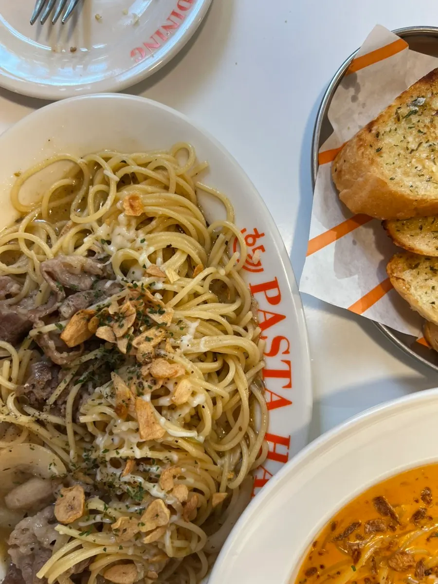 Close-up of oil pasta topped with beef brisket