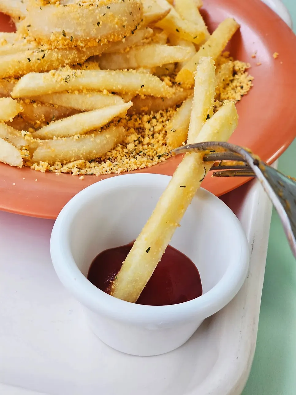 Seasoned fries dipped in ketchup