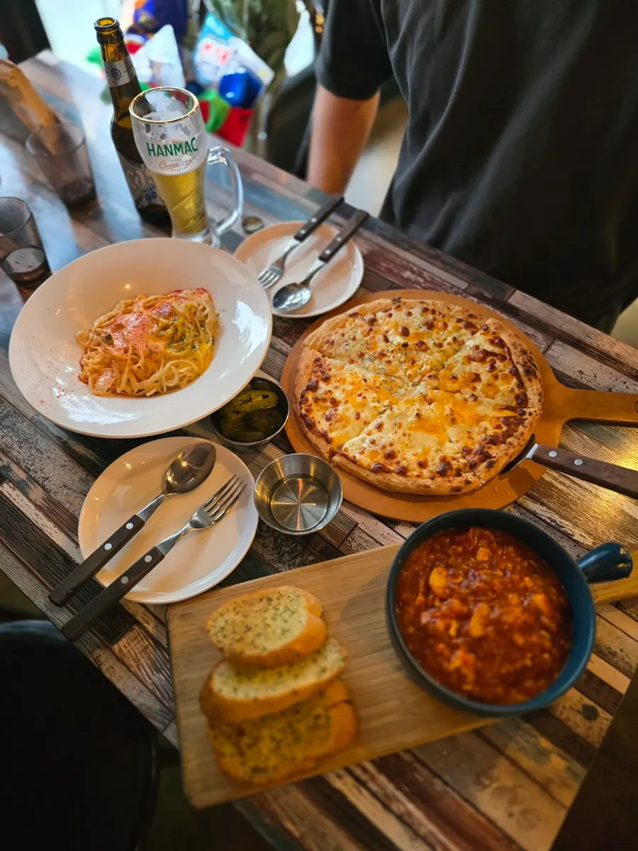 Table set with pasta, pizza, and Egg in Hell