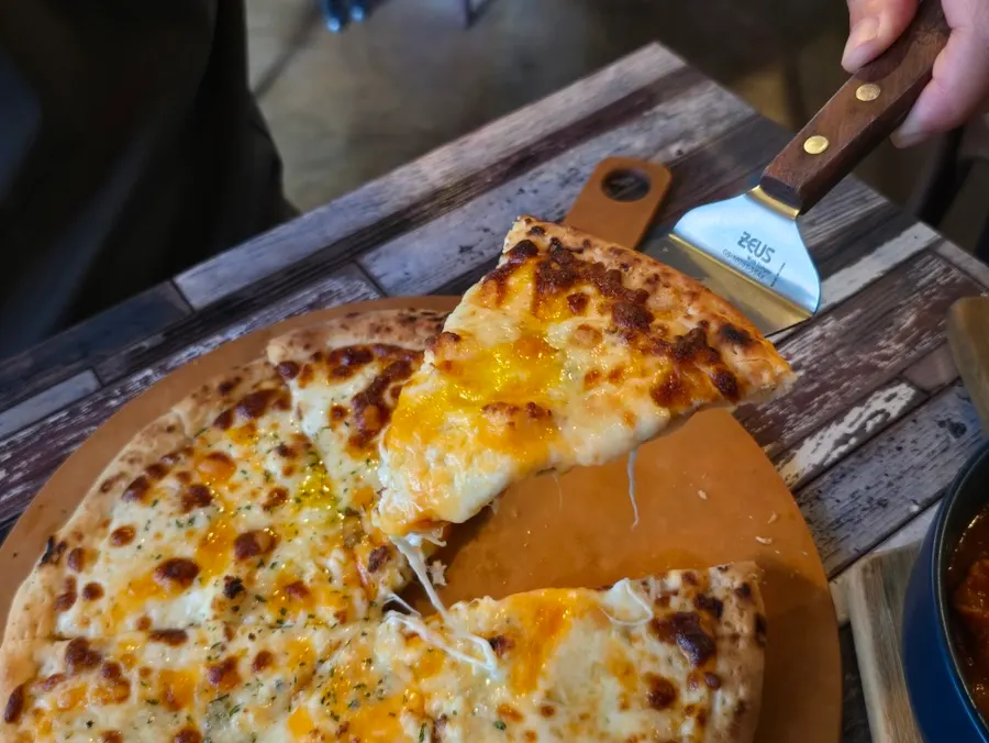 A slice of quattro cheese pizza dipped in honey
