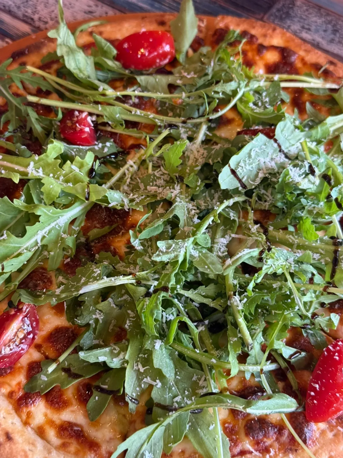 A slice of pizza piled high with rucola
