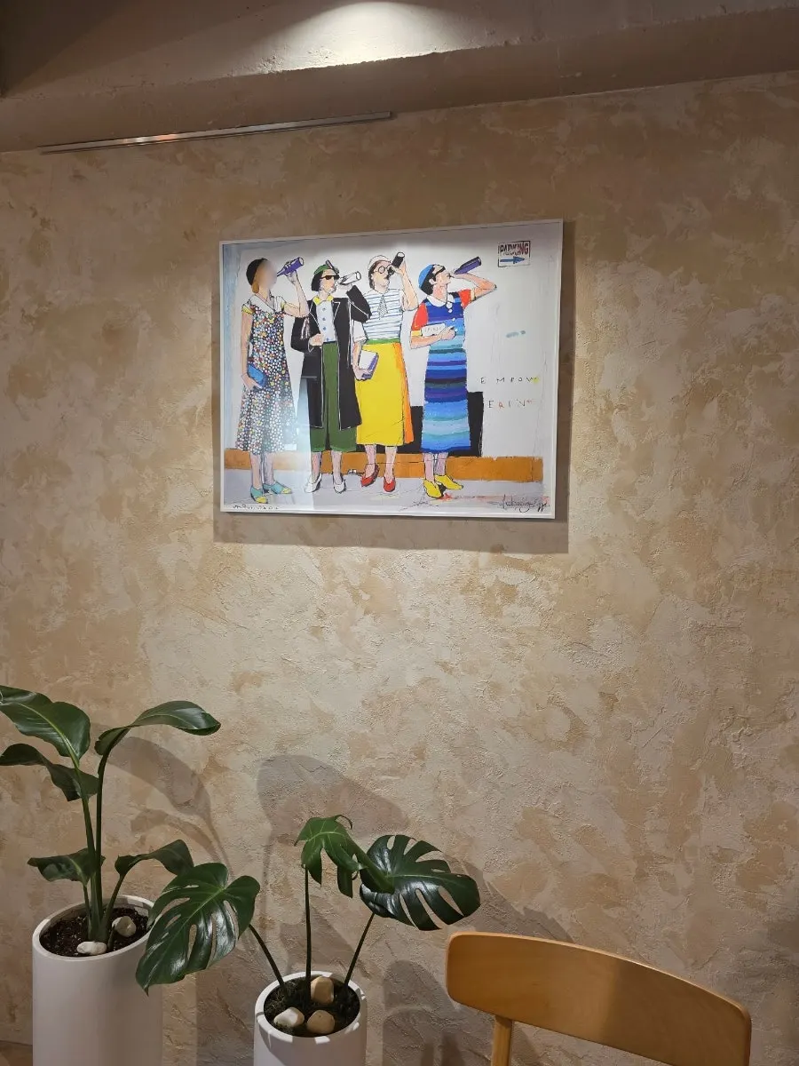 Wall decorated with paintings and a chandelier