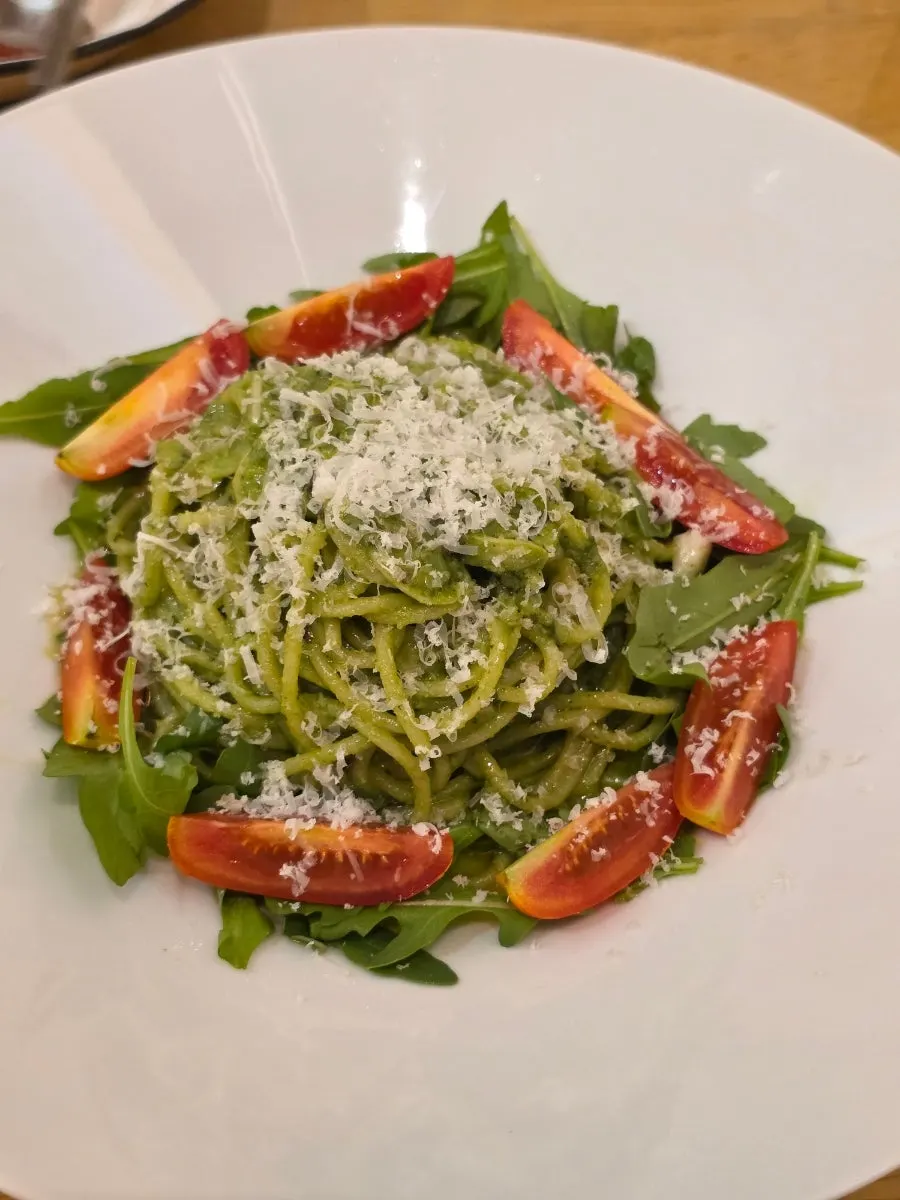 Basil pesto pasta topped with grated cheese
