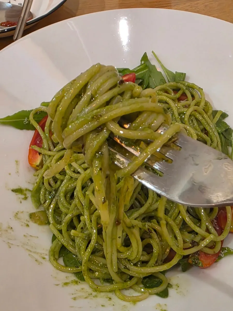 Basil pesto pasta noodles lifted with a fork
