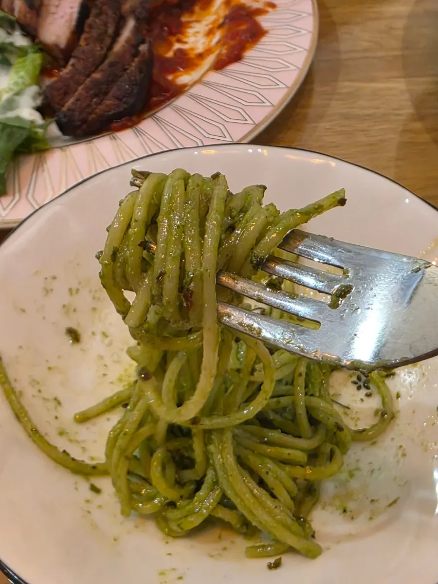 Close-up of the green basil pesto sauce coating the pasta