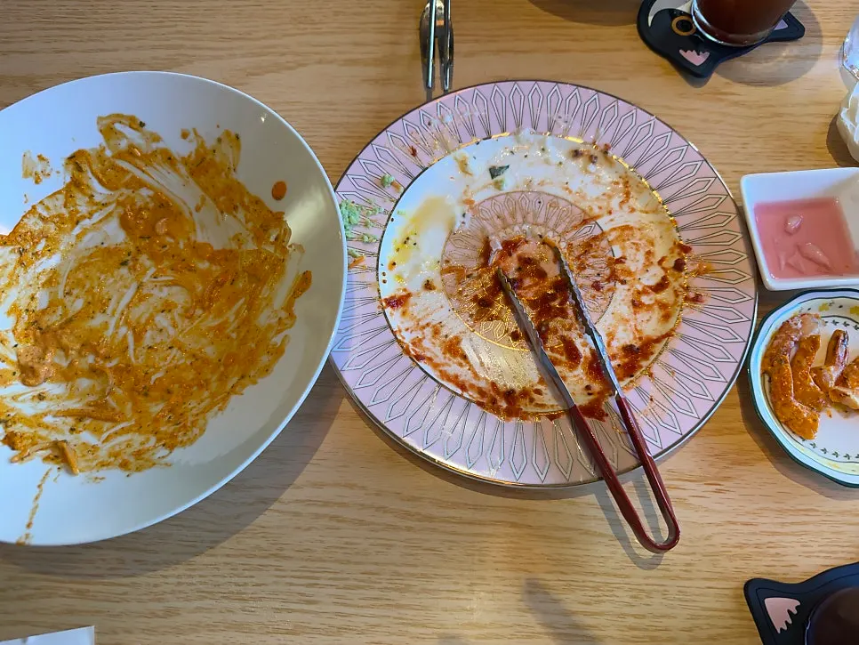 다 비운 파스타 접시와 피클 그릇