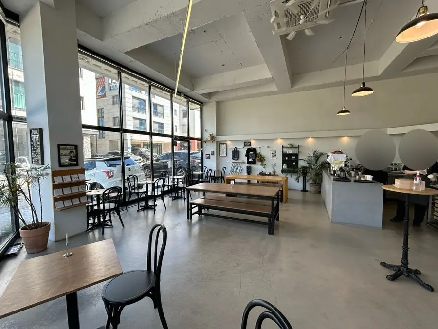 Bright interior of Pound Coffee Unjeong Main Branch with floor-to-ceiling windows