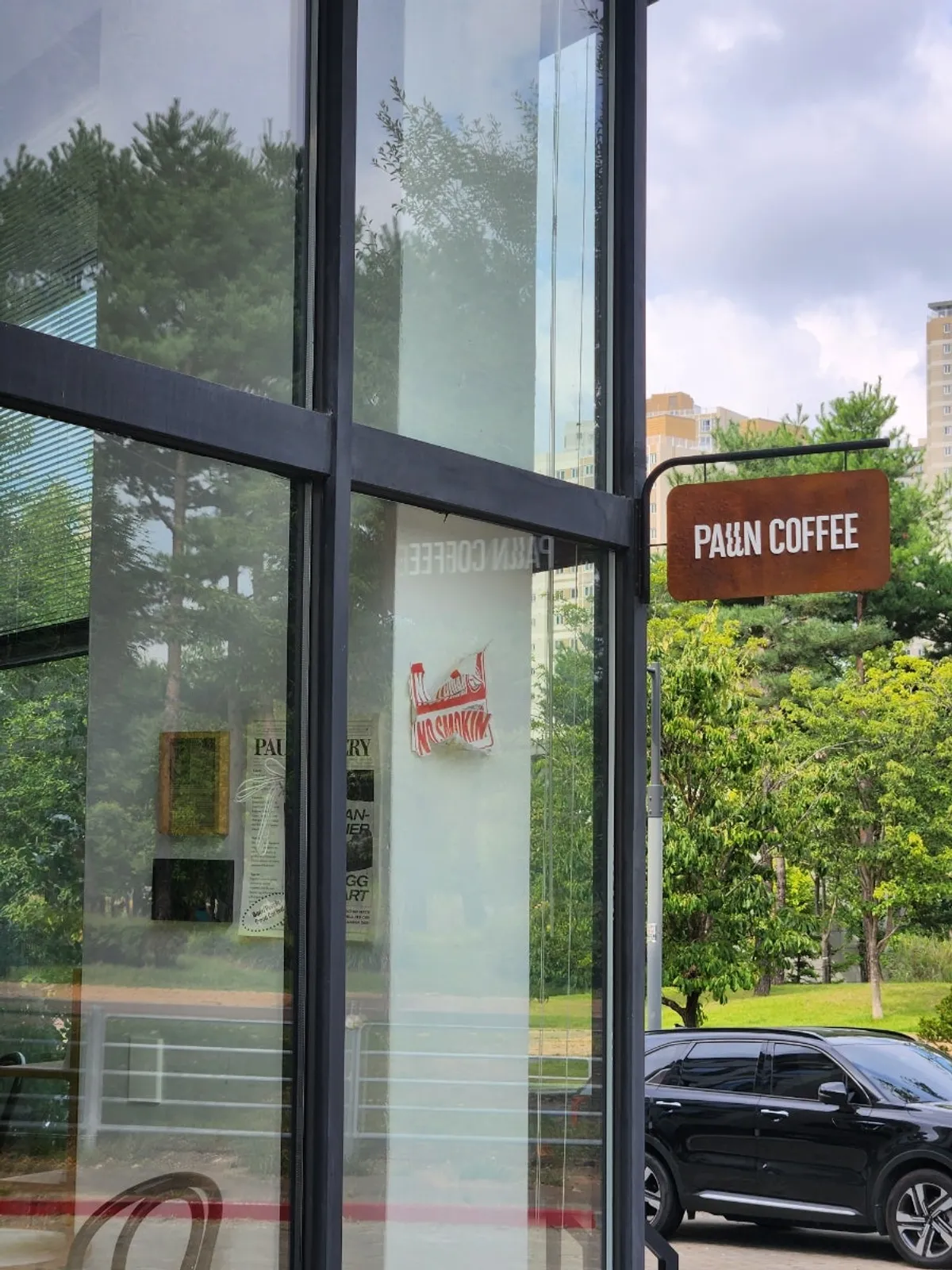 Black-framed floor-to-ceiling glass exterior of Pound Coffee Unjeong Main Branch