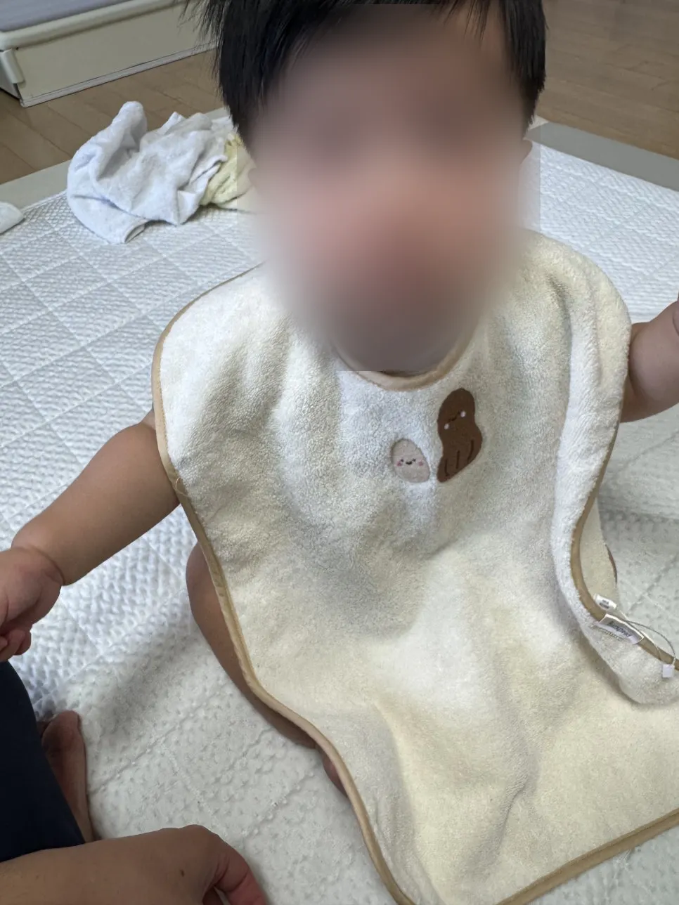 Wash bib dipakaikan pada leher bayi berusia 9 bulan
