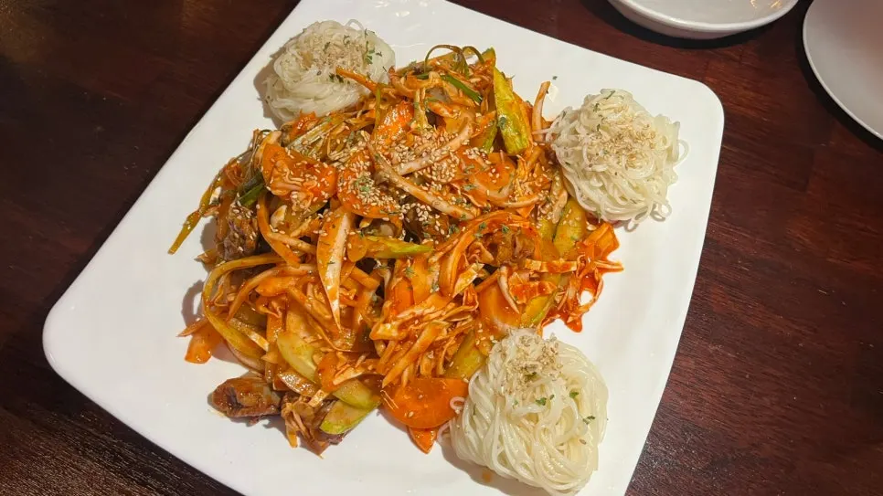 Golbaengi somyeon with whelks, vegetables, and seasoned shredded dried squid