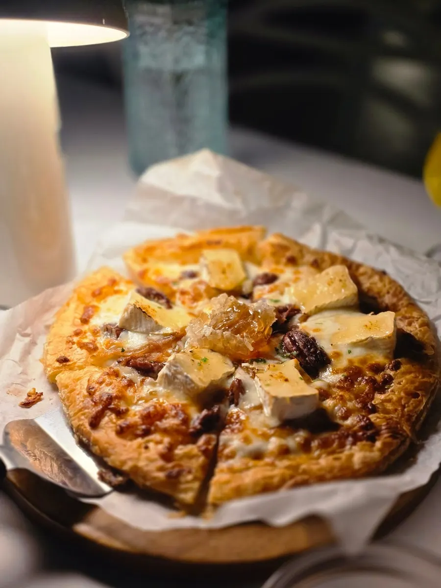 Pastry dough pizza topped with brie cheese and honey